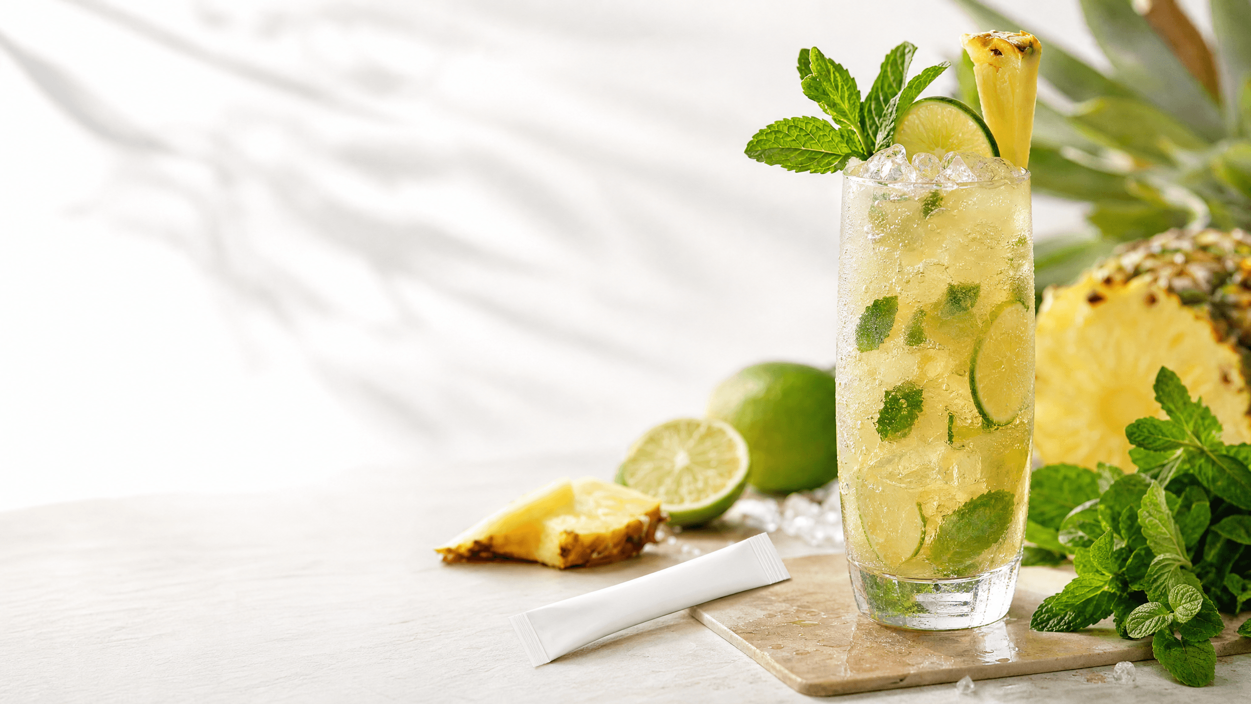 A pineapple kava nojito with mint, lime, crushed ice, and a KILA Pineapple Social Tonic on a bright bar surface
